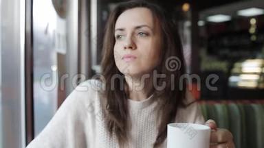 一个女人在咖啡馆喝茶，用手机社交和电子邮件。 晚餐和网页浏览